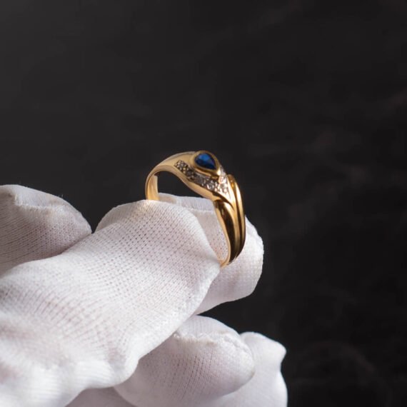 Anillo de Oro 18k con zafiro azul central y engarces de diamantes